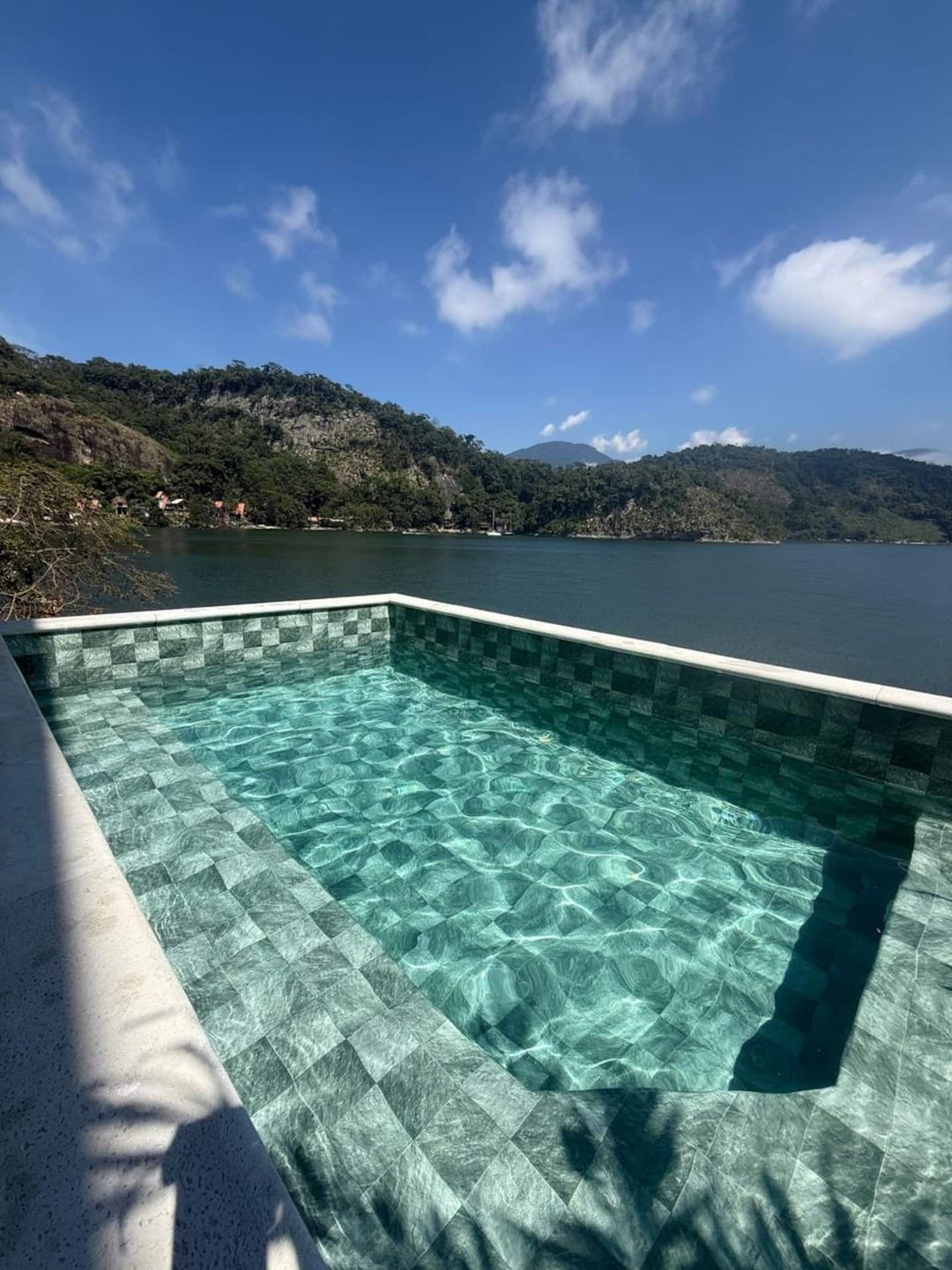 Piscina de borda infinita com vista para a baía na Casa Ponta da Ilha