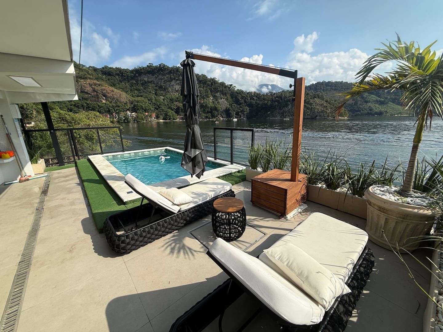 Piscina com espreguiçadeiras e vista para o mar na Casa Ponta da Ilha